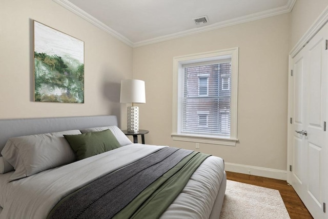 bedroom with dark hardwood / wood-style floors and crown molding