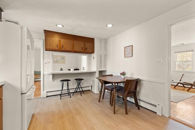 dining room with light wood-style flooring, recessed lighting, and baseboard heating