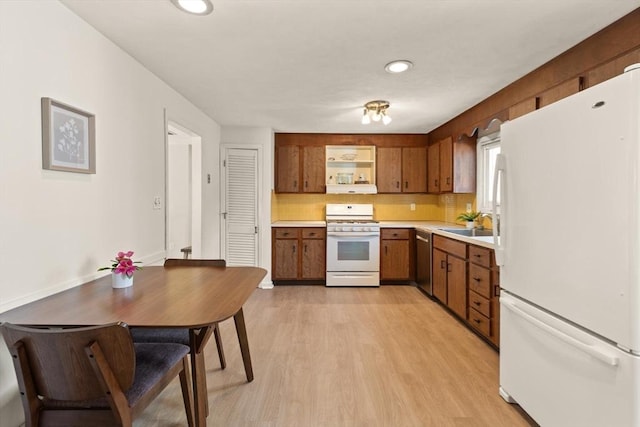 kitchen with white appliances, light wood finished floors, decorative backsplash, light countertops, and brown cabinets