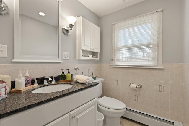 bathroom with tile patterned floors, toilet, tile walls, baseboard heating, and vanity