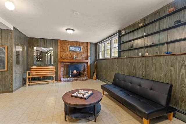 living room with tile patterned floors, wooden walls, a fireplace, and a textured ceiling