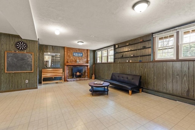 interior space featuring baseboards, wood walls, a fireplace, tile patterned floors, and a textured ceiling