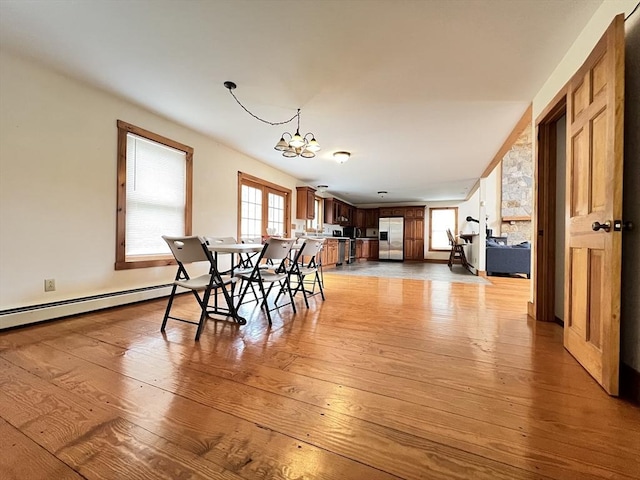 dining area featuring light wood-style flooring and a notable chandelier