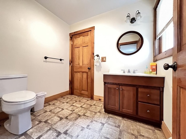 bathroom featuring baseboards, tile patterned floors, vanity, and toilet