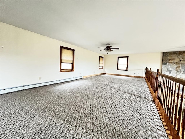 carpeted spare room with baseboards, a baseboard radiator, and a ceiling fan