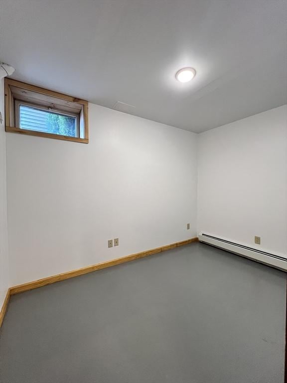 unfurnished room with baseboards, a baseboard heating unit, and finished concrete floors