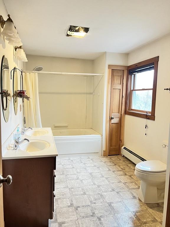full bath with shower / bath combo, vanity, toilet, tile patterned floors, and a baseboard radiator