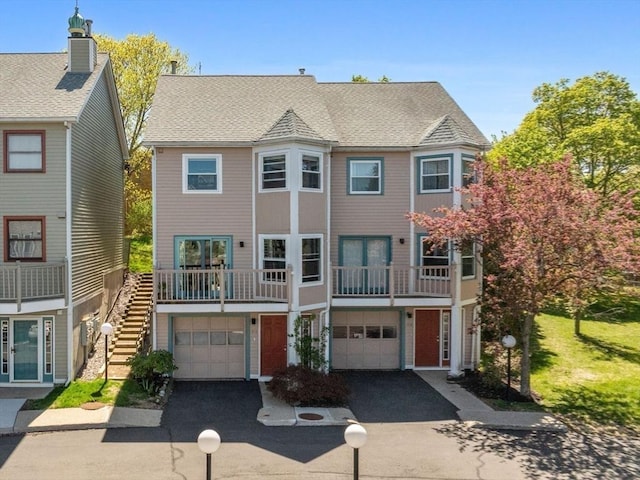 townhome / multi-family property with driveway, stairway, and a garage
