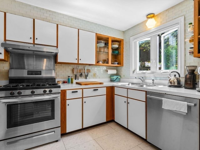 kitchen with a sink, stainless steel appliances, under cabinet range hood, backsplash, and light countertops