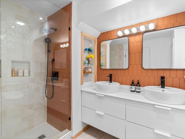 full bath featuring a sink, double vanity, and a stall shower