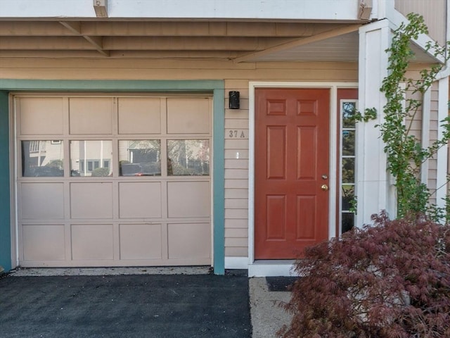 doorway to property with driveway and a garage