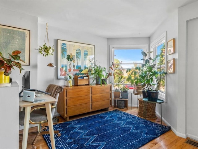 sitting room featuring baseboards, visible vents, and wood finished floors