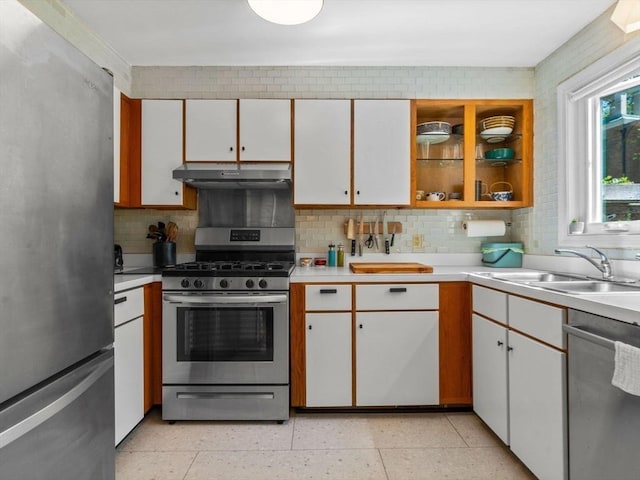 kitchen featuring a sink, stainless steel appliances, under cabinet range hood, and light countertops