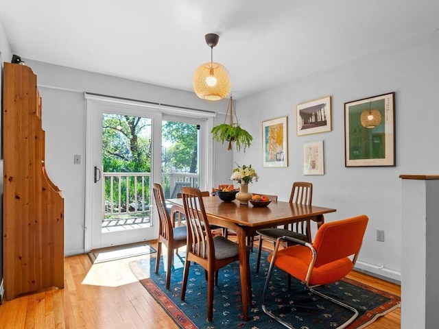 dining space with baseboards and light wood-style floors