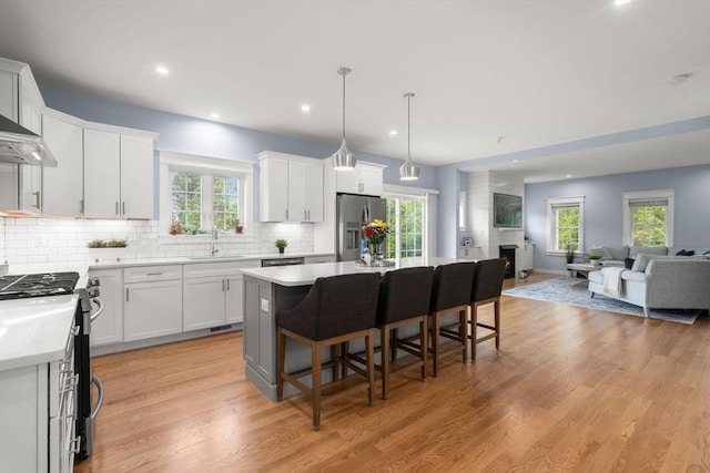 9 Baldwin Ct Unit 9, Harvard, MA 01451 - kitchen featuring stainless steel appliances, a sink, open floor plan, a center island, and decorative backsplash