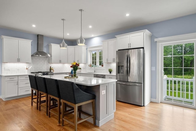 9 Baldwin Ct Unit 9, Harvard, MA 01451 - kitchen featuring stainless steel appliances, wall chimney exhaust hood, a center island, decorative backsplash, and recessed lighting