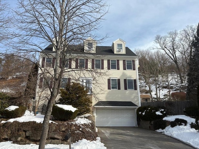 view of front of home with a garage, fence, and concrete driveway