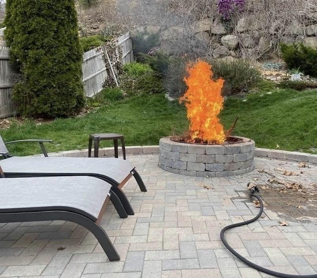 view of home's community with an outdoor fire pit, fence, and a patio