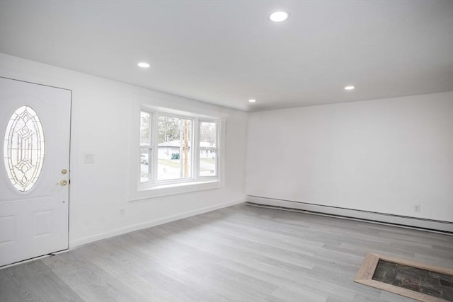 foyer with baseboard heating and light hardwood / wood-style flooring