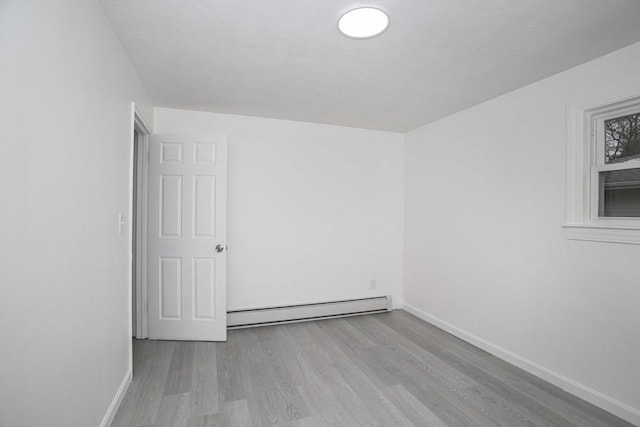 unfurnished room with light hardwood / wood-style flooring and baseboard heating