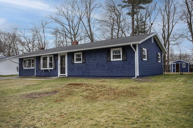 ranch-style home featuring a front lawn and a shed