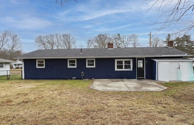 rear view of property featuring a yard, a shed, and a patio area