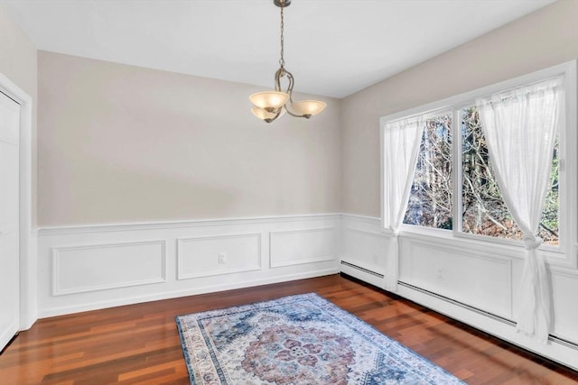 dining area with a baseboard heating unit, dark hardwood / wood-style floors, and a chandelier