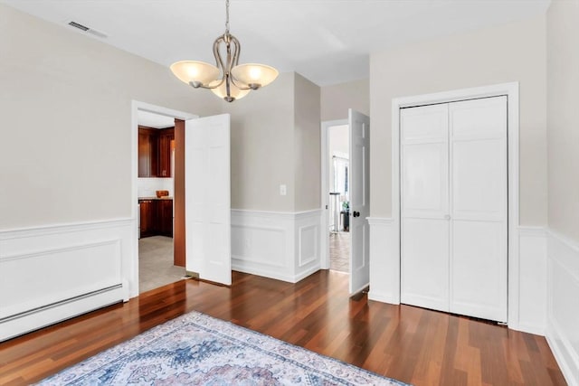 dining area featuring dark hardwood / wood-style flooring, a chandelier, and baseboard heating