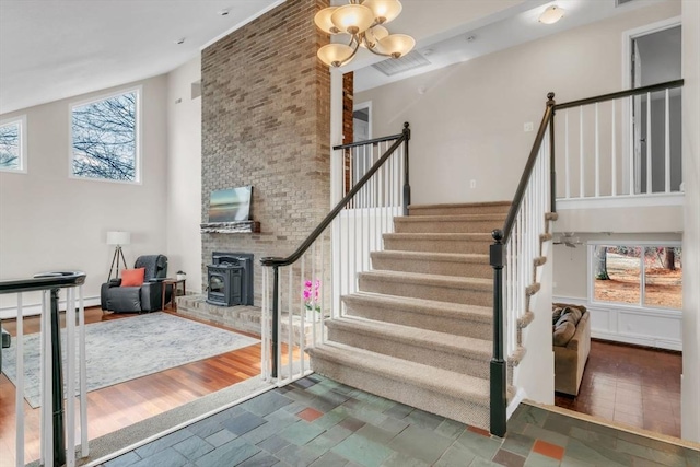 stairs featuring wood-type flooring, a wealth of natural light, and a high ceiling