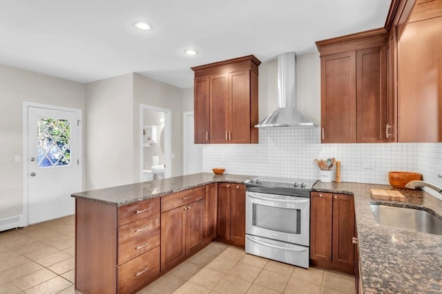 kitchen with stainless steel electric range oven, sink, dark stone countertops, kitchen peninsula, and wall chimney exhaust hood