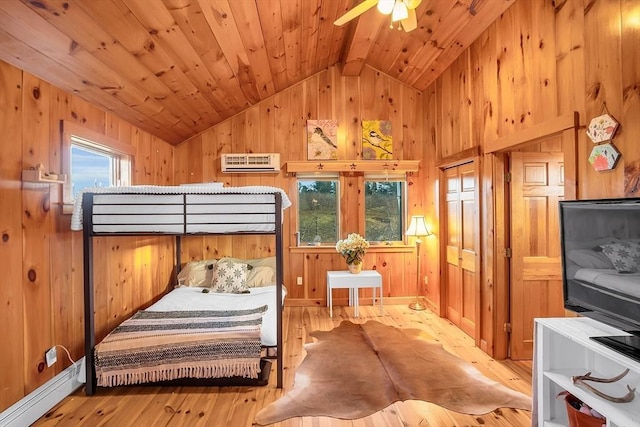 bedroom with ceiling fan, a baseboard radiator, vaulted ceiling with beams, a wall mounted AC, and light wood-type flooring