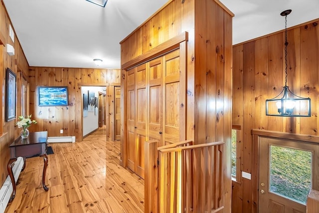 hallway featuring wood walls and a baseboard radiator