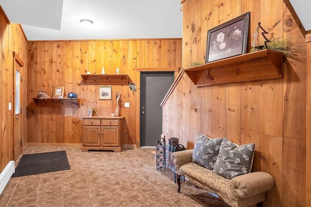 living area with wood walls and a baseboard heating unit