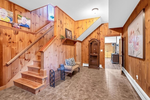 living area with wood walls and a baseboard radiator