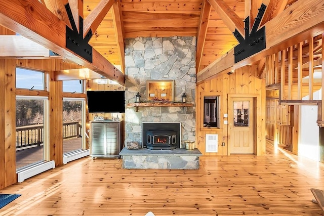 unfurnished living room with wood walls, beamed ceiling, high vaulted ceiling, and light wood-type flooring