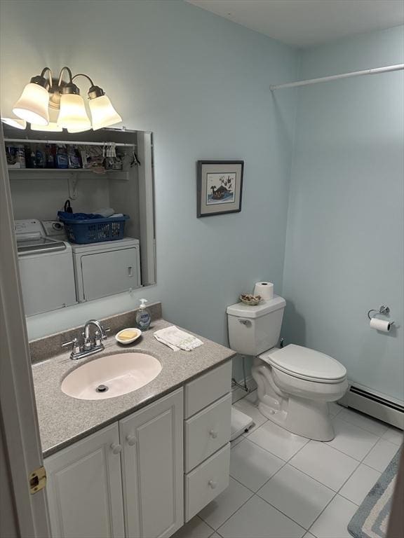 bathroom with vanity, a baseboard heating unit, toilet, washing machine and dryer, and tile patterned floors