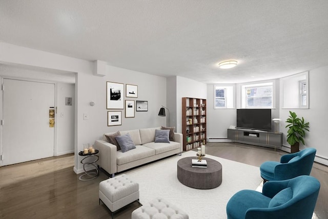 living room with hardwood / wood-style floors, baseboard heating, and a textured ceiling