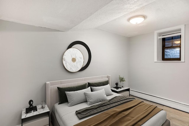 bedroom featuring a textured ceiling, wood-type flooring, baseboard heating, and vaulted ceiling