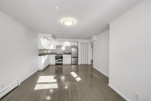 kitchen with a baseboard heating unit, white cabinets, a textured ceiling, tasteful backsplash, and stainless steel appliances