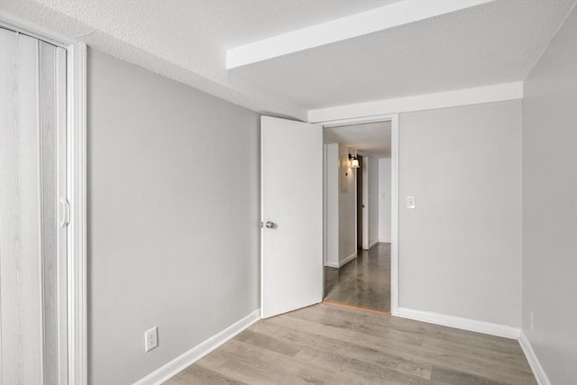 unfurnished room with light hardwood / wood-style floors and a textured ceiling