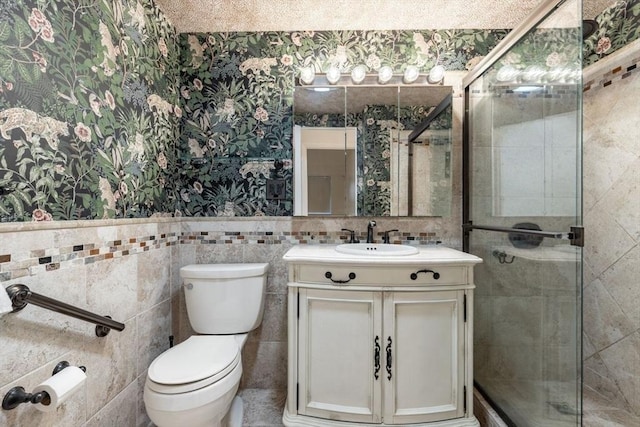 bathroom featuring a stall shower, vanity, toilet, and wallpapered walls