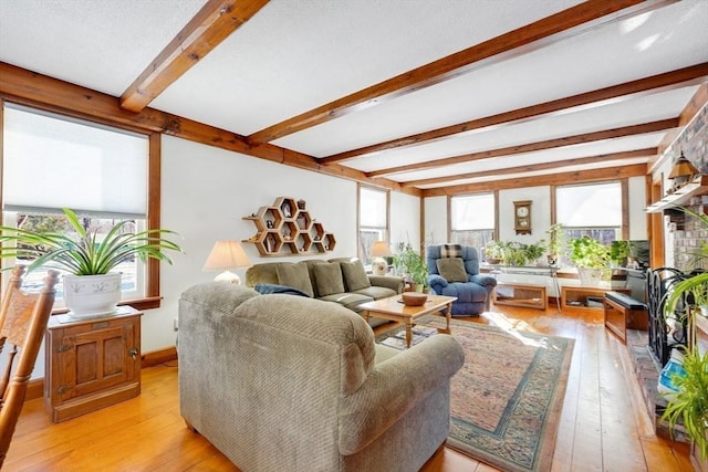 living room with beamed ceiling and light hardwood / wood-style flooring