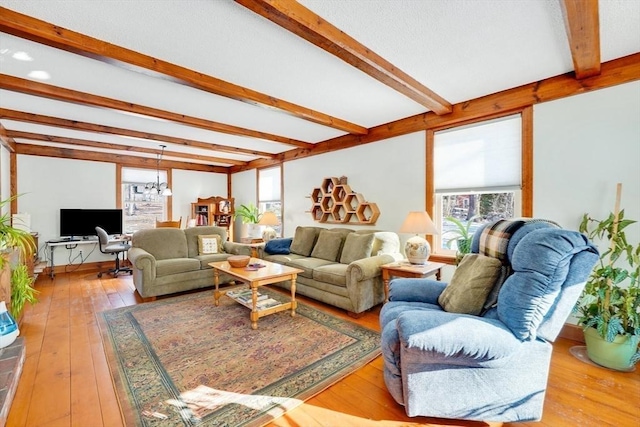 living room with beam ceiling, light hardwood / wood-style floors, and a notable chandelier