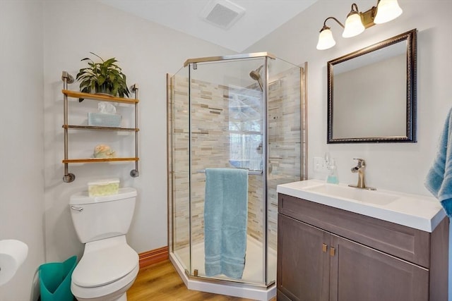 bathroom with toilet, walk in shower, vanity, and hardwood / wood-style floors