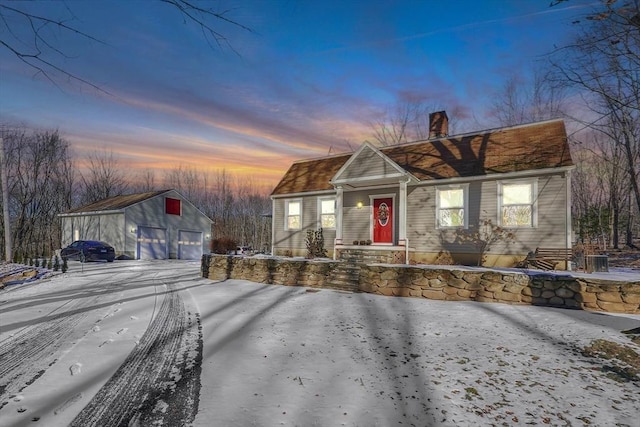 view of front of house with a garage and an outbuilding