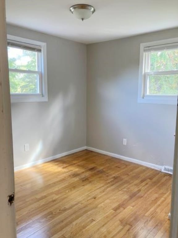 spare room featuring light hardwood / wood-style floors and a wealth of natural light