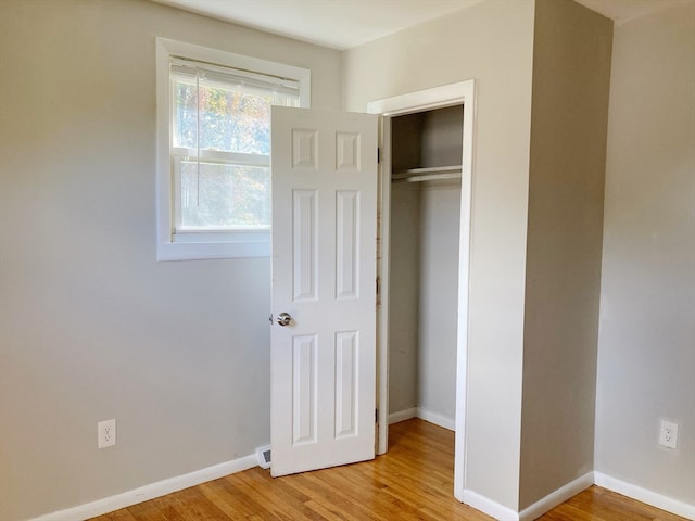 unfurnished bedroom featuring a closet and light hardwood / wood-style floors