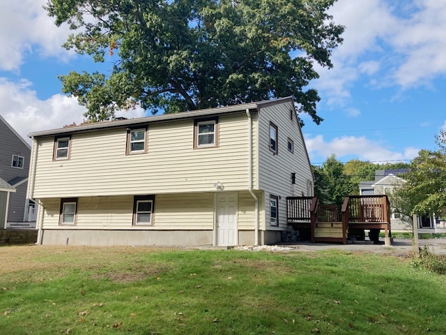 rear view of property featuring a yard and a deck