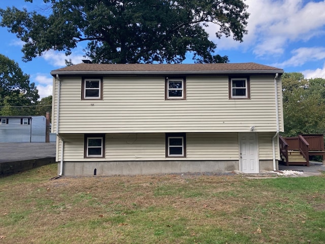 rear view of house featuring a lawn and a wooden deck