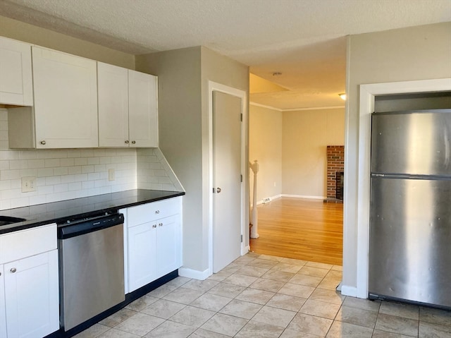 kitchen with backsplash, light hardwood / wood-style flooring, a textured ceiling, white cabinetry, and stainless steel appliances